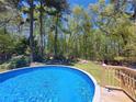 Inviting in-ground pool surrounded by a wooden deck and lush greenery, perfect for relaxation at 5539 Hurstcliffe Nw Dr, Kennesaw, GA 30152