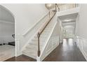 Elegant foyer featuring hardwood floors, white staircase with carpeted steps, and wainscoting at 811 Holly Mist Ct, Loganville, GA 30052