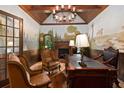 Elegant home office with wood paneled walls, custom mural, fireplace, and hardwood floors at 2740 Drayton Hall Dr, Buford, GA 30519