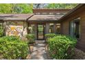 Home's entrance with a black screen door and manicured landscaping surrounding it at 3444 Wood Acres Blvd, Duluth, GA 30096