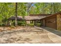 Single story home with stone accents, manicured bushes, and large driveway at 3444 Wood Acres Blvd, Duluth, GA 30096