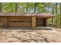Exterior shot of the garage which features stone pillars and an attached carport at 3444 Wood Acres Blvd, Duluth, GA 30096
