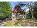 Captivating two-story home with dormer windows and a well-maintained yard with brick driveway and lush foliage at 6048 Kings Mountain Way, Tucker, GA 30087