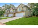 A row of new townhomes showcasing well-maintained lawns, two-car garages, and modern architectural details at 6884 Robinson St, Lithonia, GA 30058