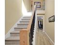 Bright foyer features a carpeted staircase with wooden handrail and iron spindles leading to the second floor at 6884 Robinson St, Lithonia, GA 30058