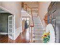 Bright two-story foyer with hardwood floors and staircase, plus decorative white trim and french doors at 725 Martin Field Dr, Lawrenceville, GA 30045
