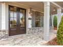 Inviting covered front entrance showcasing brickwork, gray columns, and a stylish front door with sidelights at 1010 Coleman Place Dr, Roswell, GA 30075