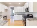 Modern kitchen featuring granite countertops, stainless steel appliances, and white cabinetry at 288 Pine Way, Dallas, GA 30157