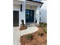 Home entrance featuring beautiful landscaping, colorful flowers, and a paved walkway at 685 Summitt Hill Way, Cumming, GA 30040