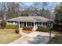 Inviting single-story home with a well-manicured lawn and mature shrubbery accentuating the exterior at 1721 Hudson Woods Trl, Decatur, GA 30033