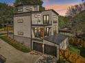 Rear view of a modern home with a garage, balconies, a metal roof, and nestled in a lush, green landscape at , Atlanta, GA 30310