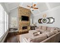 Cozy living room with stone fireplace, vaulted ceiling, and comfortable seating, perfect for relaxing and entertaining at 2032 Grovewood Ct, Cumming, GA 30041