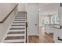 Inviting entryway with hardwood floors leading to staircase and open kitchen area at 2413 Malster Ln, Lawrenceville, GA 30043