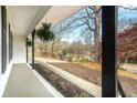 Inviting covered front porch with hanging plants and a scenic view of the front yard at 4646 Mountain Creek Ne Dr, Roswell, GA 30075