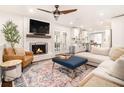 Cozy living room features a painted brick fireplace, ceiling fan, and an open view of the kitchen at 4646 Mountain Creek Ne Dr, Roswell, GA 30075