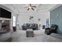 Spacious living room featuring a stone fireplace, coffered ceilings, and stylish furnishings at 527 Mossycup Dr, Fairburn, GA 30213