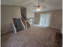Spacious living room featuring plush carpeting, a ceiling fan, and access to the backyard at 6301 Creekford Dr, Lithonia, GA 30058