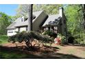 A side view of the house showing the garage and a partially wooded lot at 1521 Larkwood Dr, Canton, GA 30114