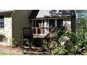 A closer view of the front entrance featuring a deck with stairs and lush landscaping at 1521 Larkwood Dr, Canton, GA 30114