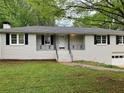 Charming home with a white brick facade, black shutters, and a well-maintained lawn at 1871 Kinridge Rd, Marietta, GA 30062