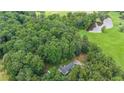 Overhead shot of a home near a pond and open fields, surrounded by a dense tree line at 527 Gaddis Rd, Canton, GA 30115