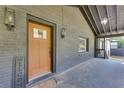 Cozy front porch featuring a brick wall, stained front door and modern lighting at 1705 Ezra Church Nw Dr, Atlanta, GA 30314