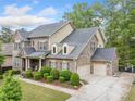 Charming brick home with a three-car garage, landscaped front yard, and classic architectural details at 626 Oakbourne Way, Woodstock, GA 30188