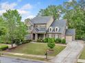 Charming two-story brick home featuring well-maintained landscaping and a long driveway at 626 Oakbourne Way, Woodstock, GA 30188