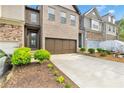 Beautiful townhome featuring a large driveway, two-car garage, and manicured landscaping enhancing curb appeal at 7545 Roseberry Way, Lithonia, GA 30038