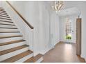Bright and open foyer with hardwood floors, a staircase with wooden railing, and modern lighting at 7545 Roseberry Way, Lithonia, GA 30038