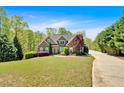 Attractive home with lush landscaping and a long, paved driveway at 7801 Windswept Way, Douglasville, GA 30135