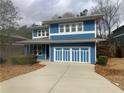 Charming two-story home featuring a blue exterior, well-maintained landscaping, and a spacious driveway at 2331 Bouldercliff Se Way, Atlanta, GA 30316