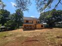 Back exterior view of two-story house under construction surrounded by an expansive yard with mature trees at 3920 Bellair Dr, Marietta, GA 30066