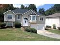 Two-story home featuring an attached garage, a manicured lawn and mature trees at 9399 Whaleys Lake Ln, Jonesboro, GA 30238