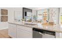 Modern kitchen with granite countertops, stainless steel appliances, and a view into the living area at 1002 Sutherland Lane (Lot 36), Lawrenceville, GA 30043