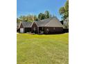 View of the brick house from the backyard, showcasing the lush lawn at 2608 Cascade Cove Dr, Buford, GA 30519