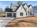 Side view of a white two story home with a three car garage and manicured landscaping at 3735 Tamiami Trl, Cumming, GA 30041
