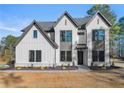 View of a two story home with gray trim, a black front door and yellow shrubbery at 3735 Tamiami Trl, Cumming, GA 30041