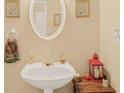 Half bathroom with a pedestal sink, decorative mirror, and neutral wall color at 4034 Brockett Walk, Tucker, GA 30084