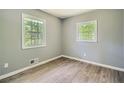 Bedroom featuring wood-look floors, neutral walls, and two sunny windows at 1679 Hollyhock Ter, Decatur, GA 30032