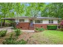 Well-maintained single-story home with a brick facade, covered carport, and landscaped front yard at 3800 Whitaker Ln, Lithia Springs, GA 30122
