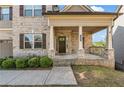 Inviting front porch featuring brick columns and covered entry with sidelights at 1285 Brynhill Ct, Buford, GA 30518