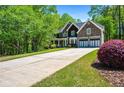 Long driveway leading to a beautifully landscaped home with lush greenery and mature trees at 1326 Benbrooke Nw Ln, Acworth, GA 30101