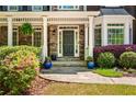 Inviting front entry with stone facade, potted plants, and covered porch at 1326 Benbrooke Nw Ln, Acworth, GA 30101