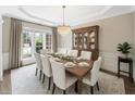 Staged dining room featuring a decorative chandelier and a large dining table at 1330 Badingham Dr, Cumming, GA 30041