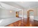 Spacious living area featuring hardwood floors, elegant chandelier and detailed trim at 1330 Badingham Dr, Cumming, GA 30041
