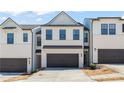Modern townhome featuring a two-car garage and a stylish, symmetrical facade at 1028 Sutherland Lane (Lot 45), Lawrenceville, GA 30043