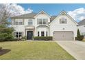 Beautiful two-story home with manicured lawn, front shrubs, and a two-car garage at 6060 Country Lake Rd, Cumming, GA 30041