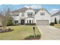 Charming two-story home with a well-manicured lawn, two-car garage, and beautiful landscaping at 6060 Country Lake Rd, Cumming, GA 30041