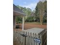 Private backyard with a small patio, wooden fence, and a sign for Glover Fence at 2012 Grove Park Ct, Marietta, GA 30062